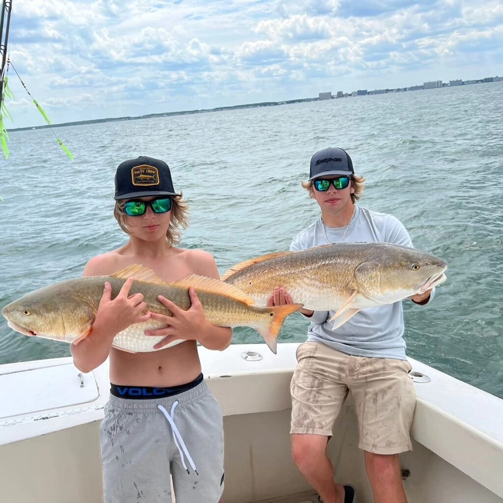 Two men holding their catch - Drum fish on Sea Teaser Sport Fishing